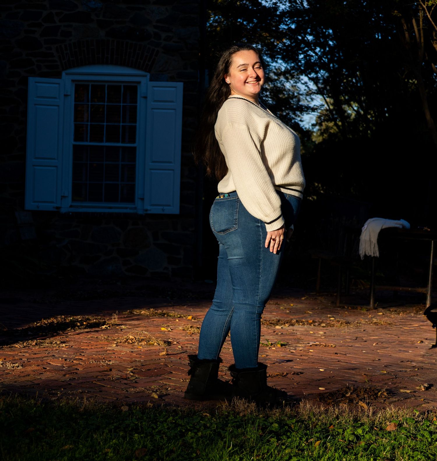 A sequence of playful poses against a brick building and autumn leaves at sunset.