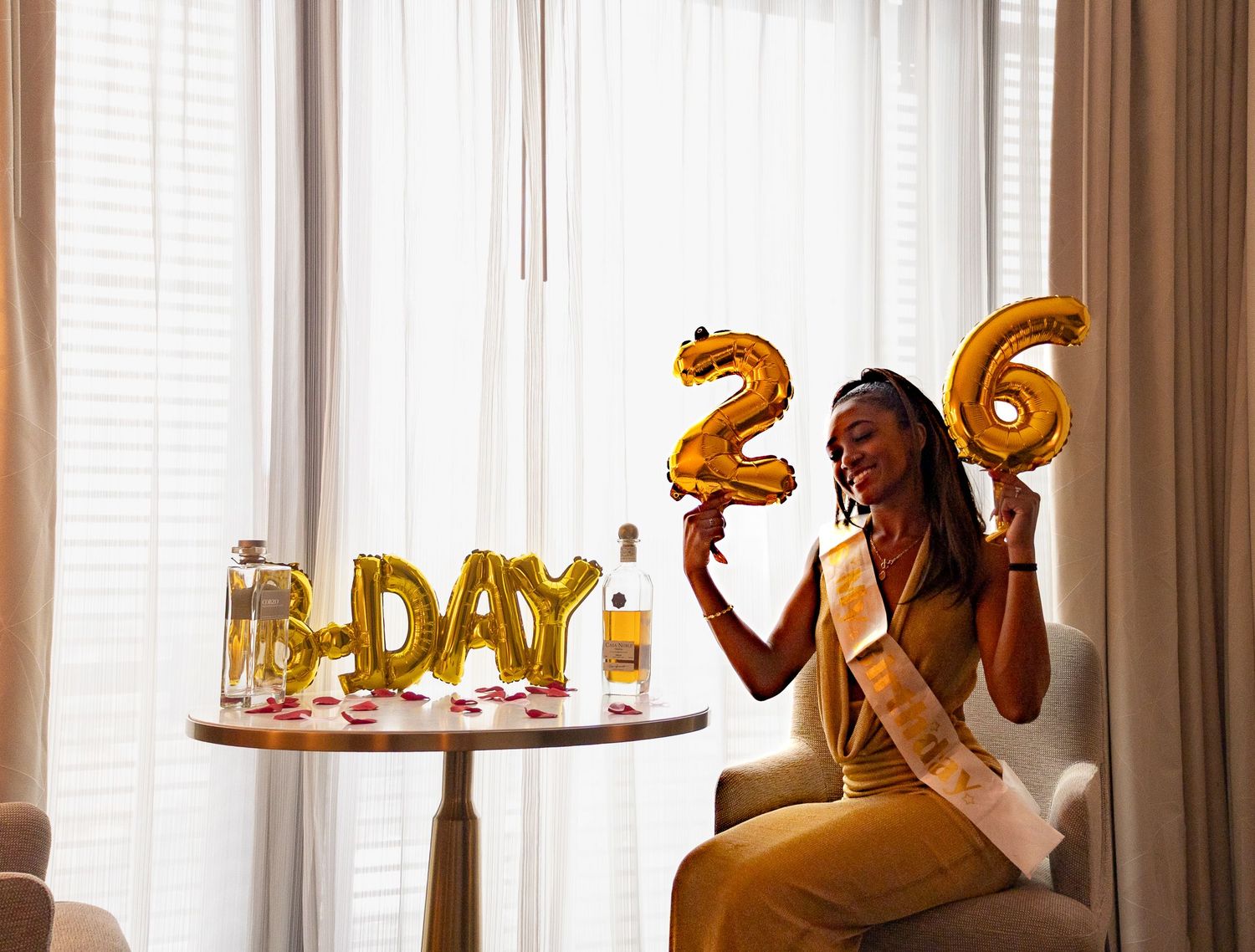 Elegant indoor setting with golden balloon decorations and window light.