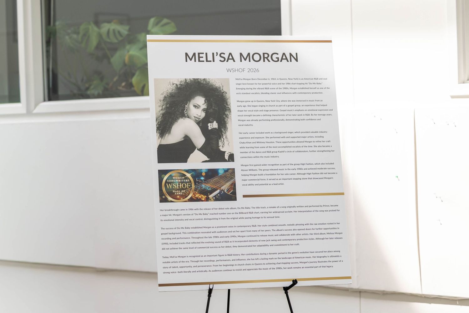 Meli'sa Morgan biography display board on easel at an event or exhibition.