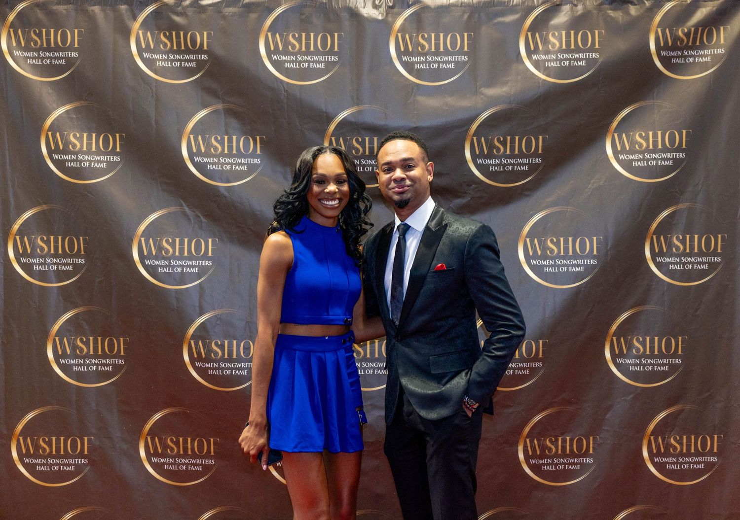 A man and woman pose together on a red carpet at the WSHOF awards event, dressed in elegant formal attire.