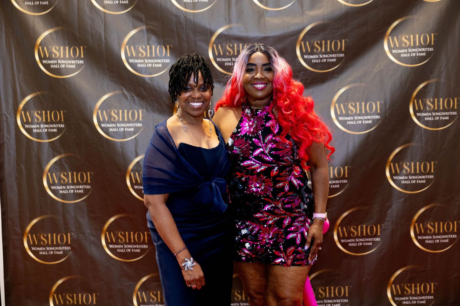 Two women pose together on a WSHOF Women Songwriters Hall of Fame red carpet event.