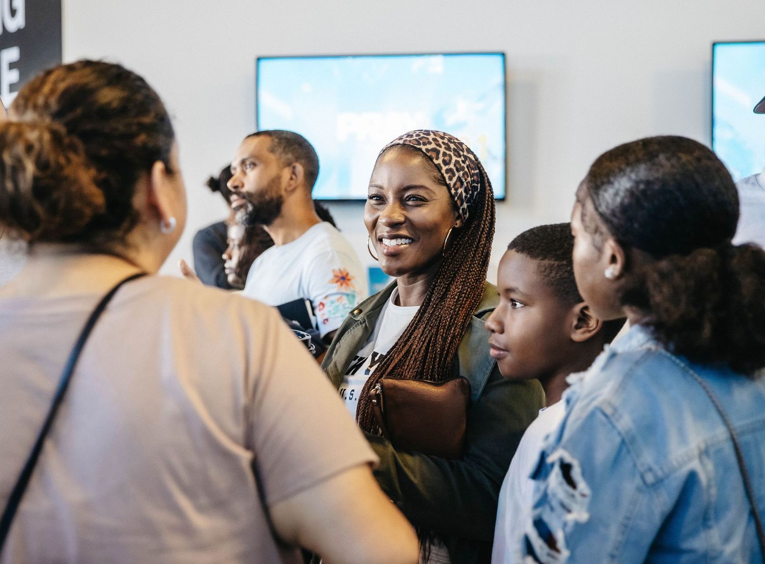 People gathered for a community discussion with bright expressions and engaged body language.