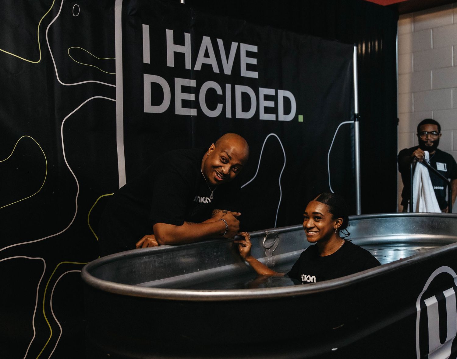 A person lies in a bathtub with a contemplative expression while text on the wall reads 'I HAVE DECIDED'.