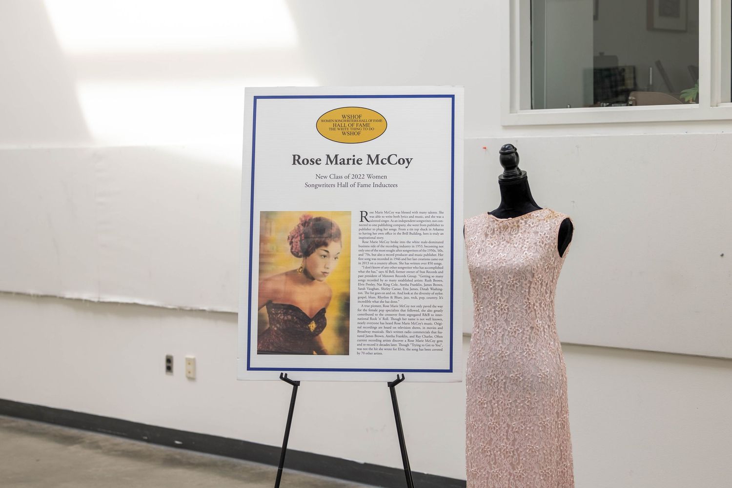 Rose Marie McCoy Hall of Fame display board with biography and vintage pink beaded gown on mannequin.