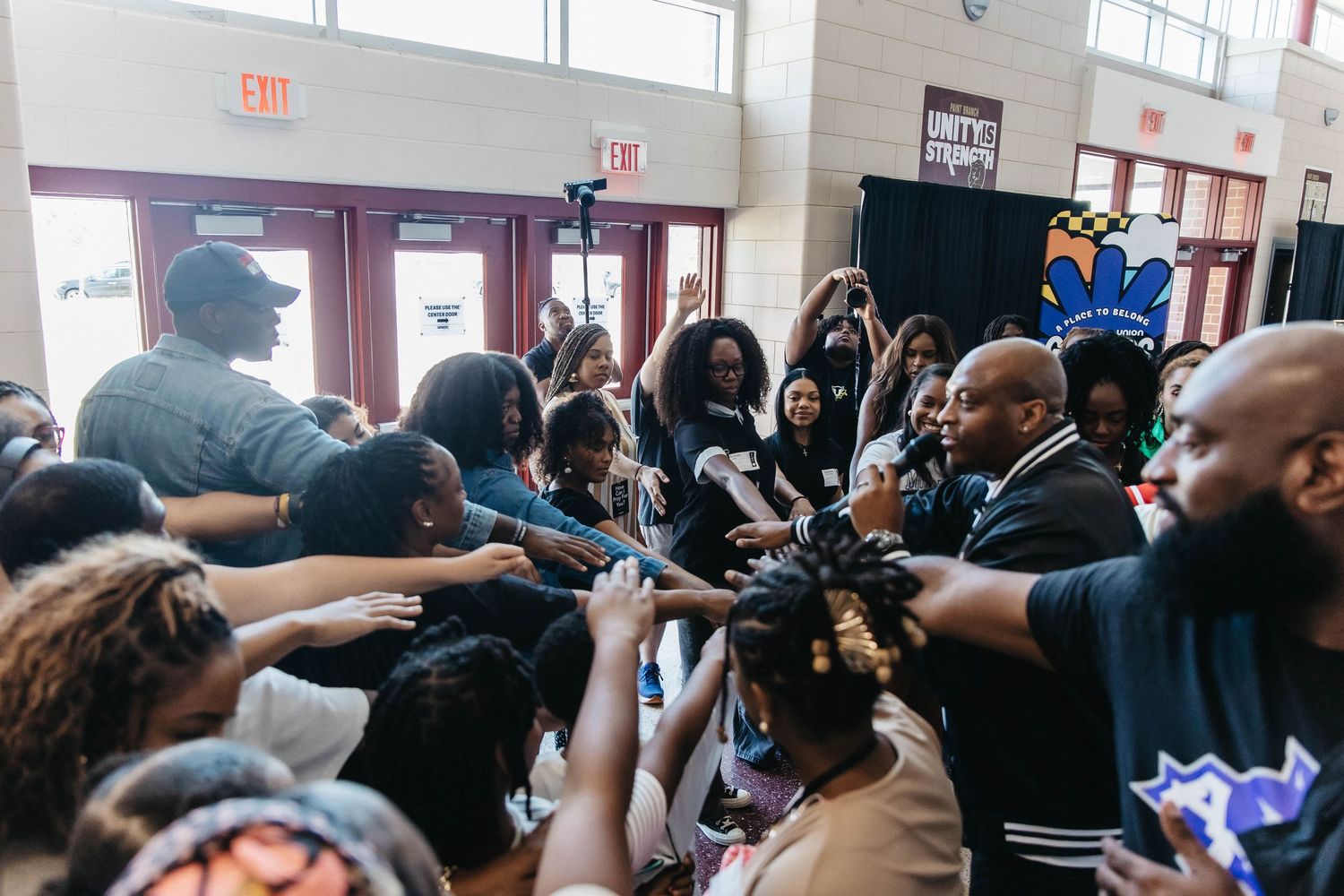 Large crowd of people gathered indoors at a community event with high energy and excitement.