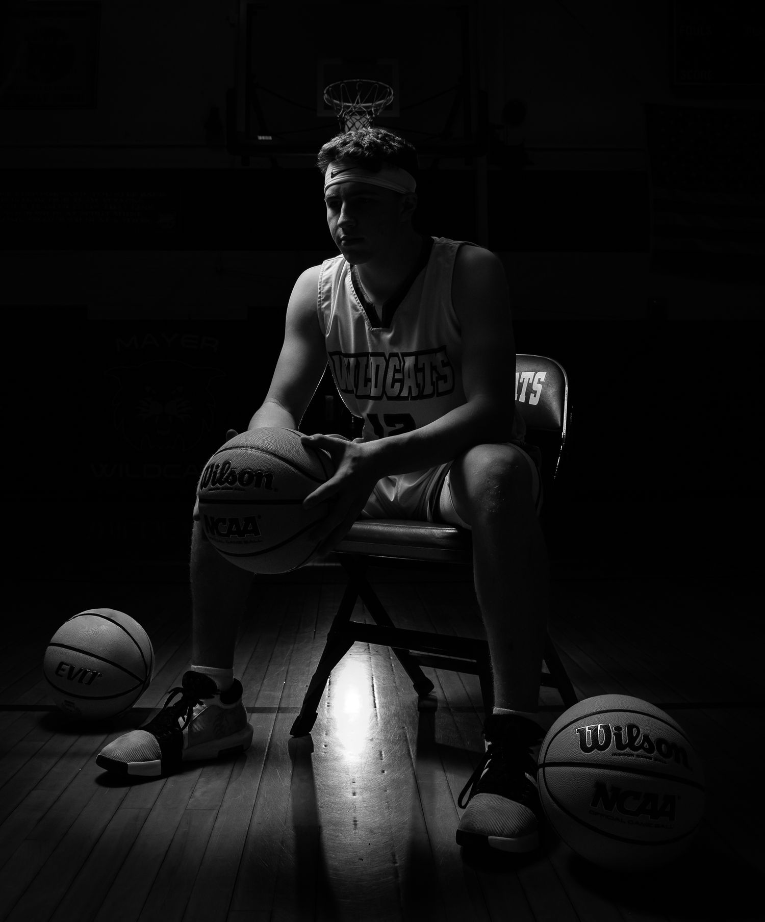 Moody basketball themed photoshoot with dramatic lighting and multiple basketballs.
