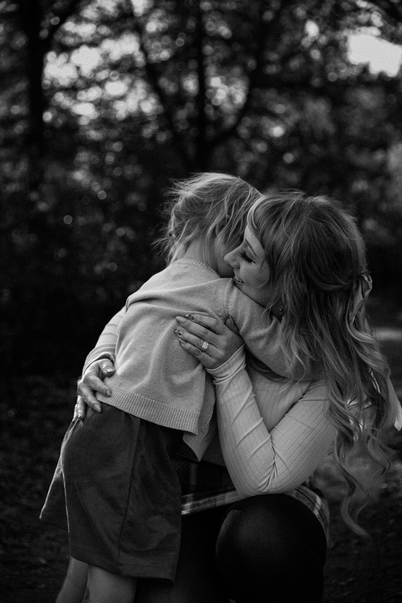 Intimate black and white sequence showing tender moments in a forest setting.