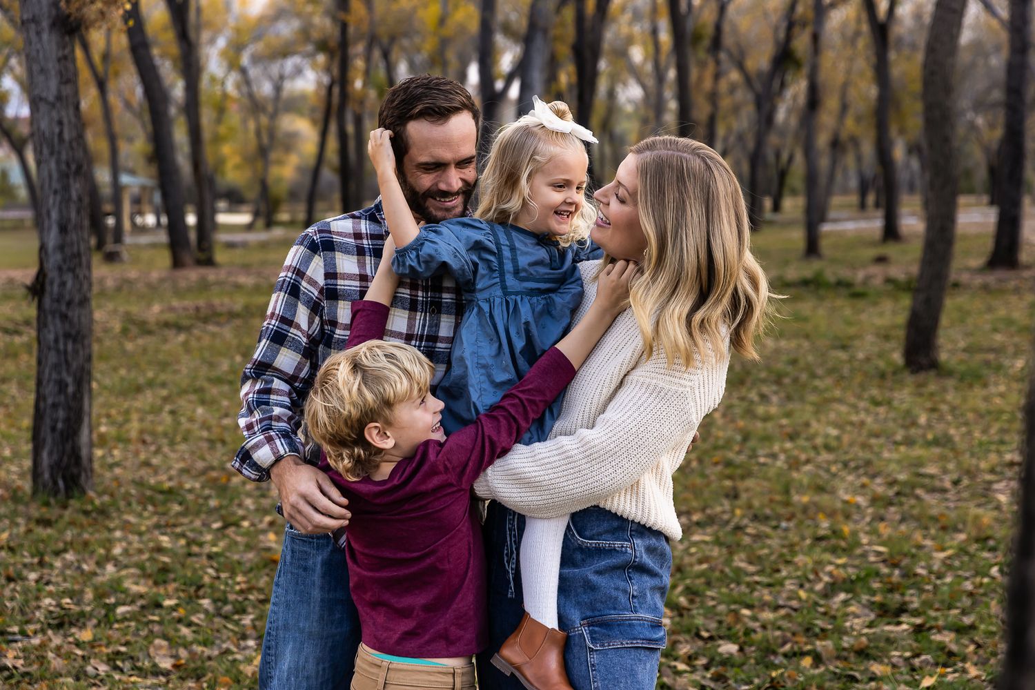 Family enjoying autumn day together in park with fall foliage in background. dead horse ranch arizona