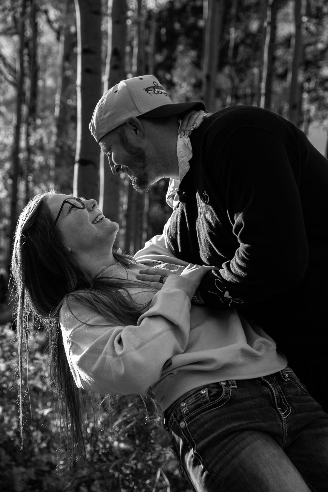 A black and white photo series shows two people embracing passionately in a forest setting. in flagstaff Arizona photographer