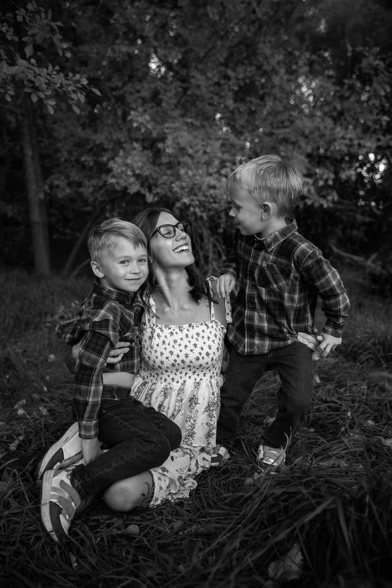 A black and white photo series shows a child in a polka dot dress playing and posing in tall grass outdoors.