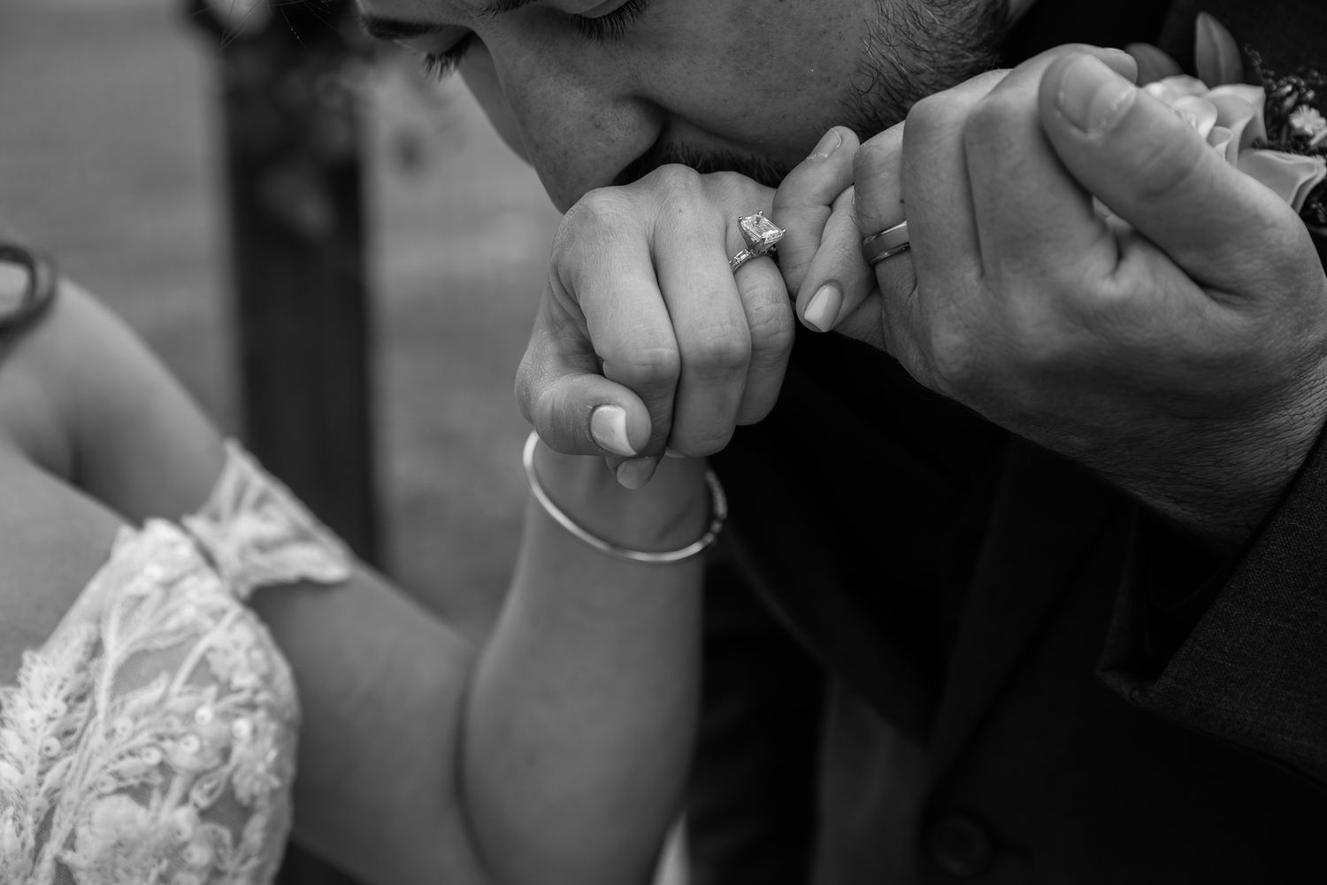 Close-up black and white shot of hands during an intimate moment.