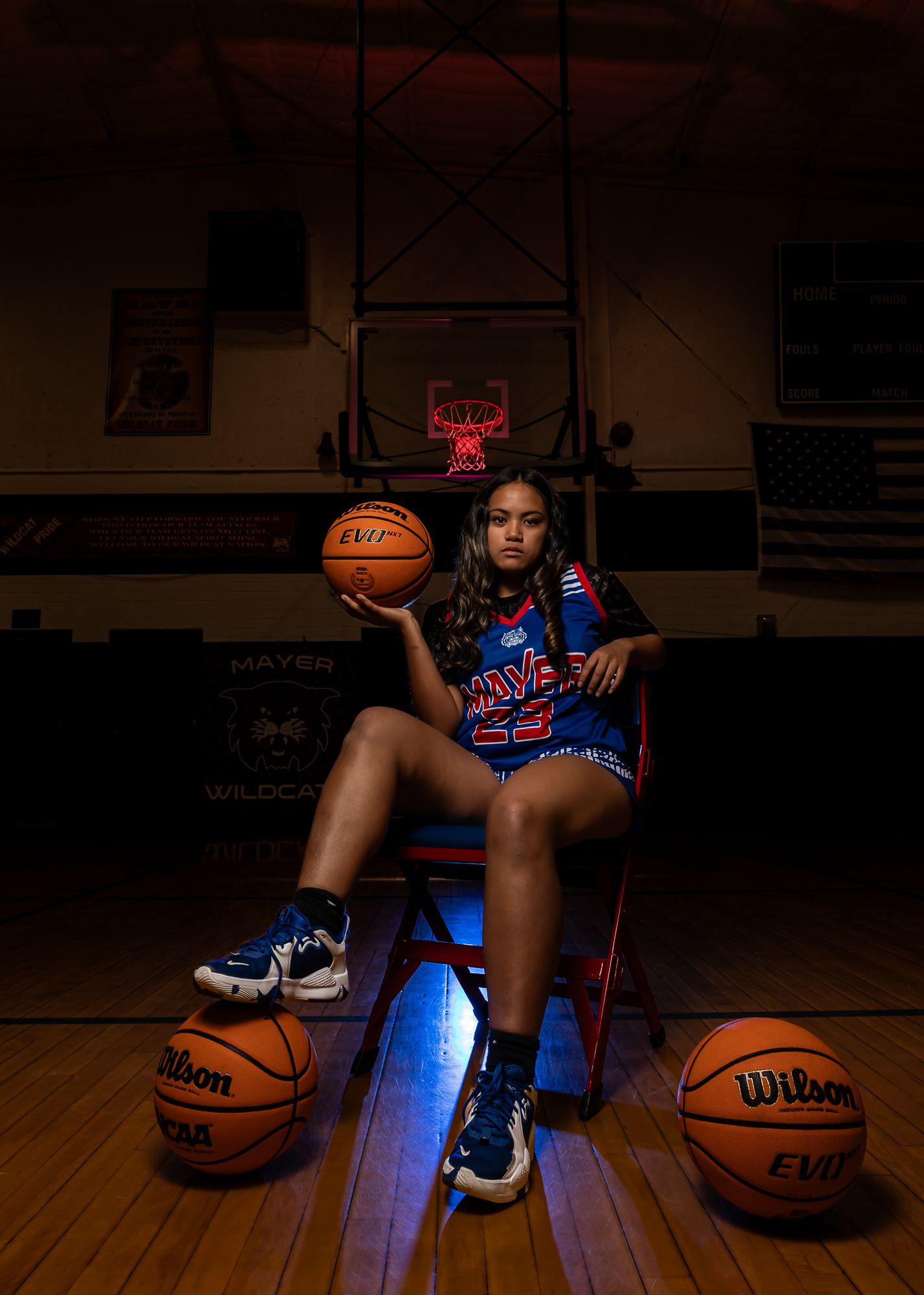 Dramatic sports portrait with basketballs and blue lighting on wooden court. arizona sports photography