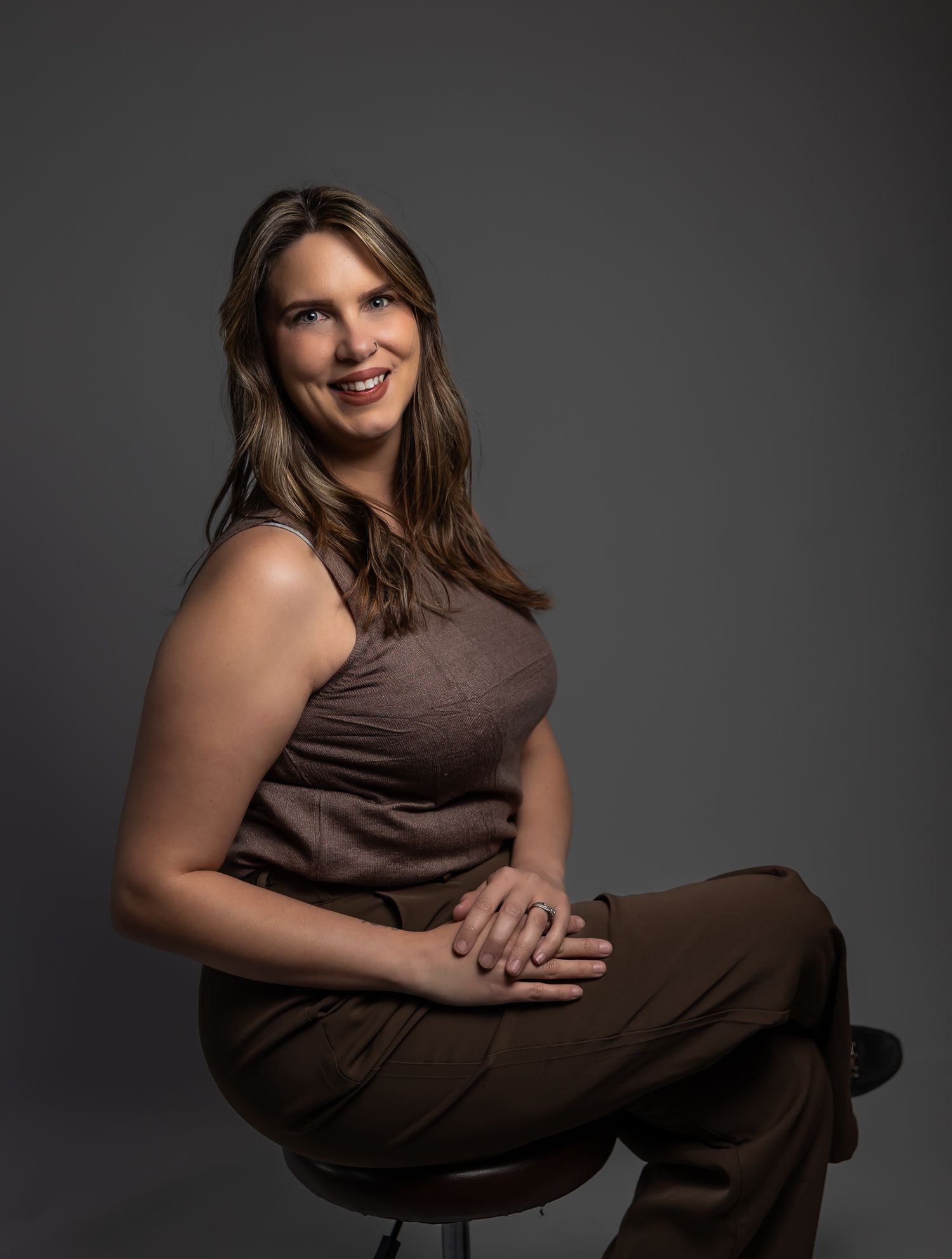 A series of artistic portrait photos showing a person in a brown dress against a dark background in various seated poses. Arizona studio