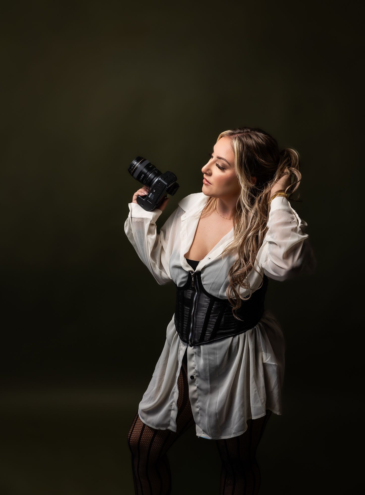 Dramatic portrait series of a woman in white blouse against dark background with expressive poses. arizona photographer in her studio