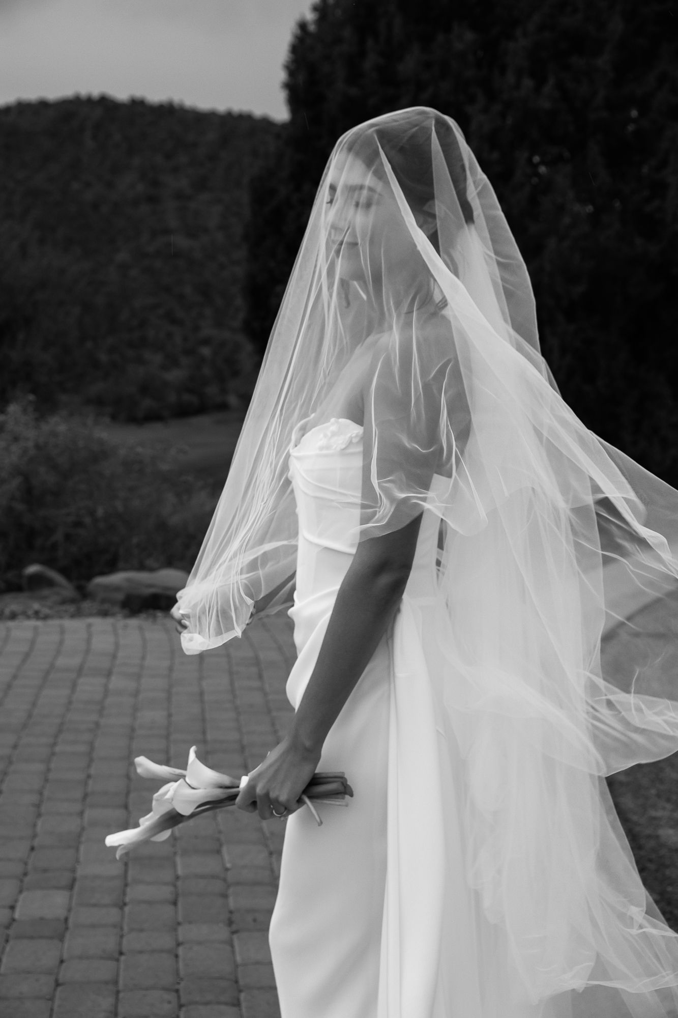 A flowing white wedding veil billows in the breeze behind a bride in an elegant white dress. Sedona golf resort. bridal Jerome .arizona