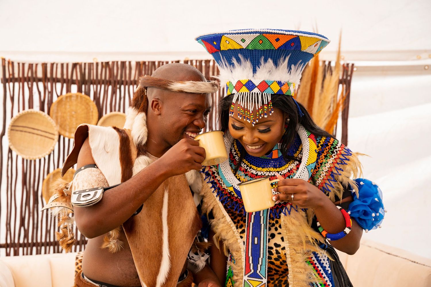 A couple in traditional Zulu attire sharing a joyful moment during a cultural ceremony.