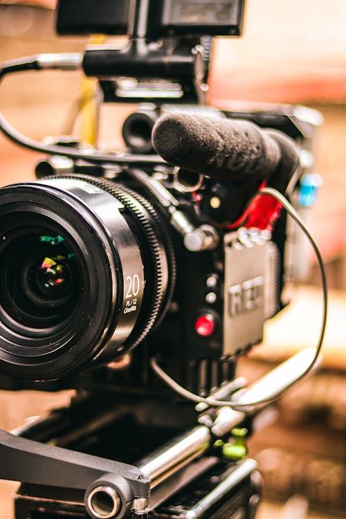 Professional RED cinema camera with a 20mm lens and shotgun microphone mounted on a film production rig.