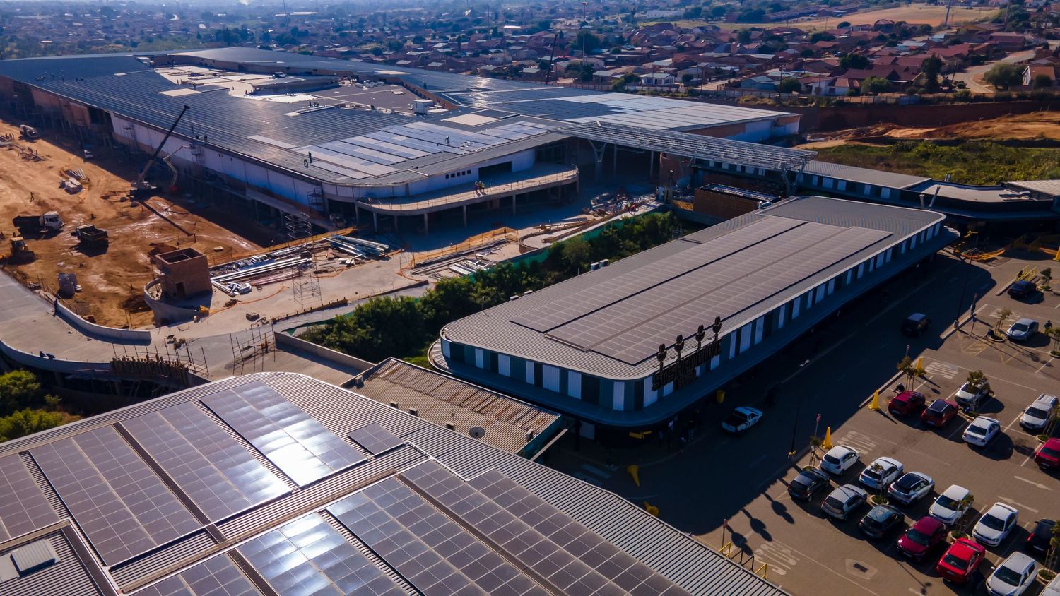Aerial view of a large industrial warehouse complex with solar panels on the rooftop.
