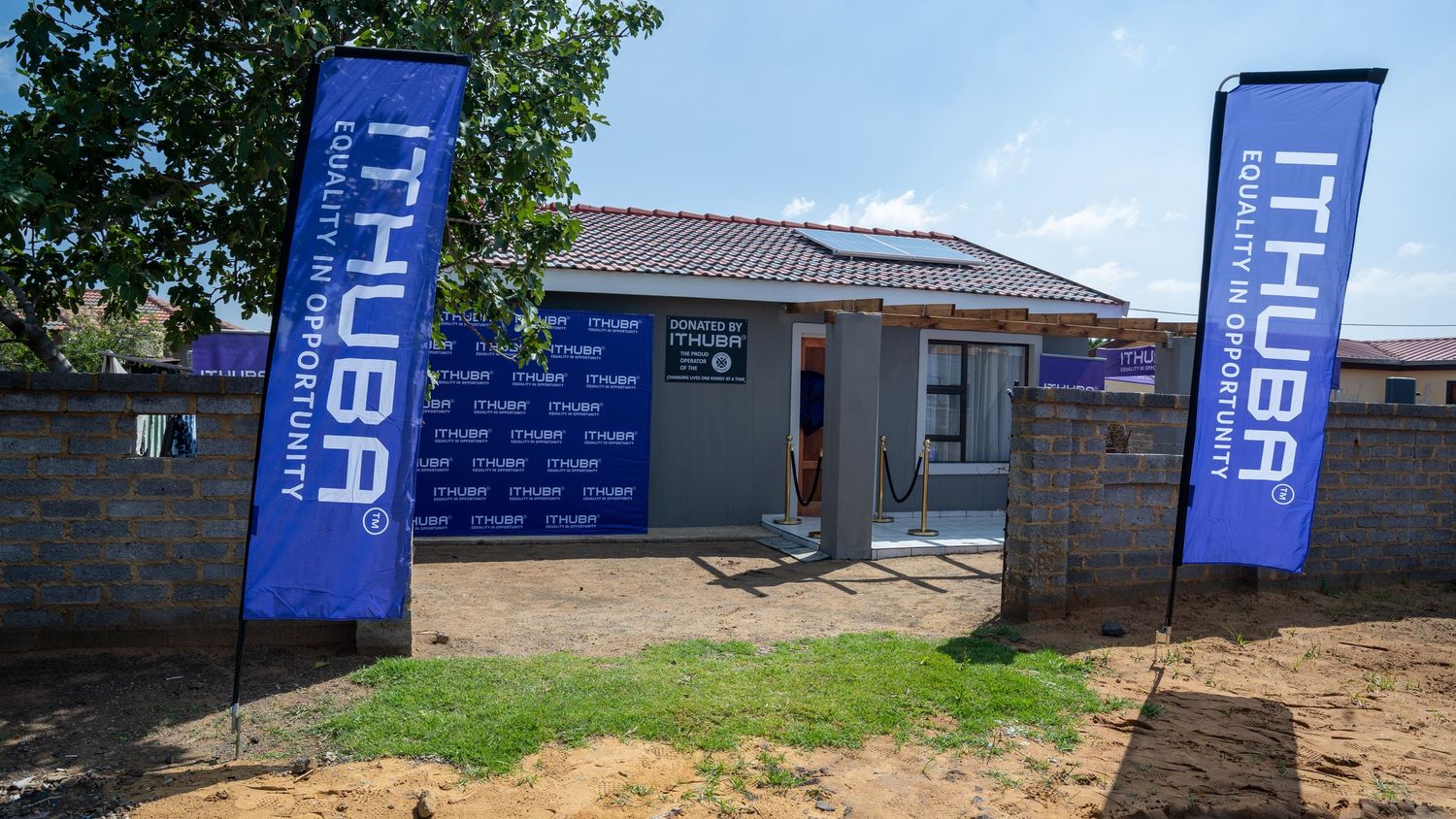 Ithuba lottery branded blue banners flank the entrance of a newly built house in South Africa.