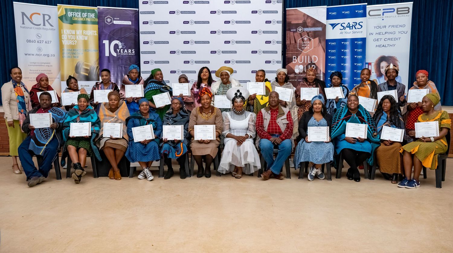 Large group of certificate recipients pose together at a SARS and NCR community empowerment graduation ceremony.