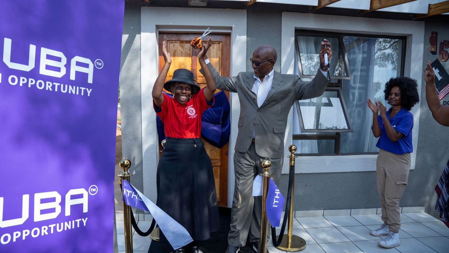 Two people cut a ribbon at the grand opening of an Ithuba-sponsored home in South Africa.