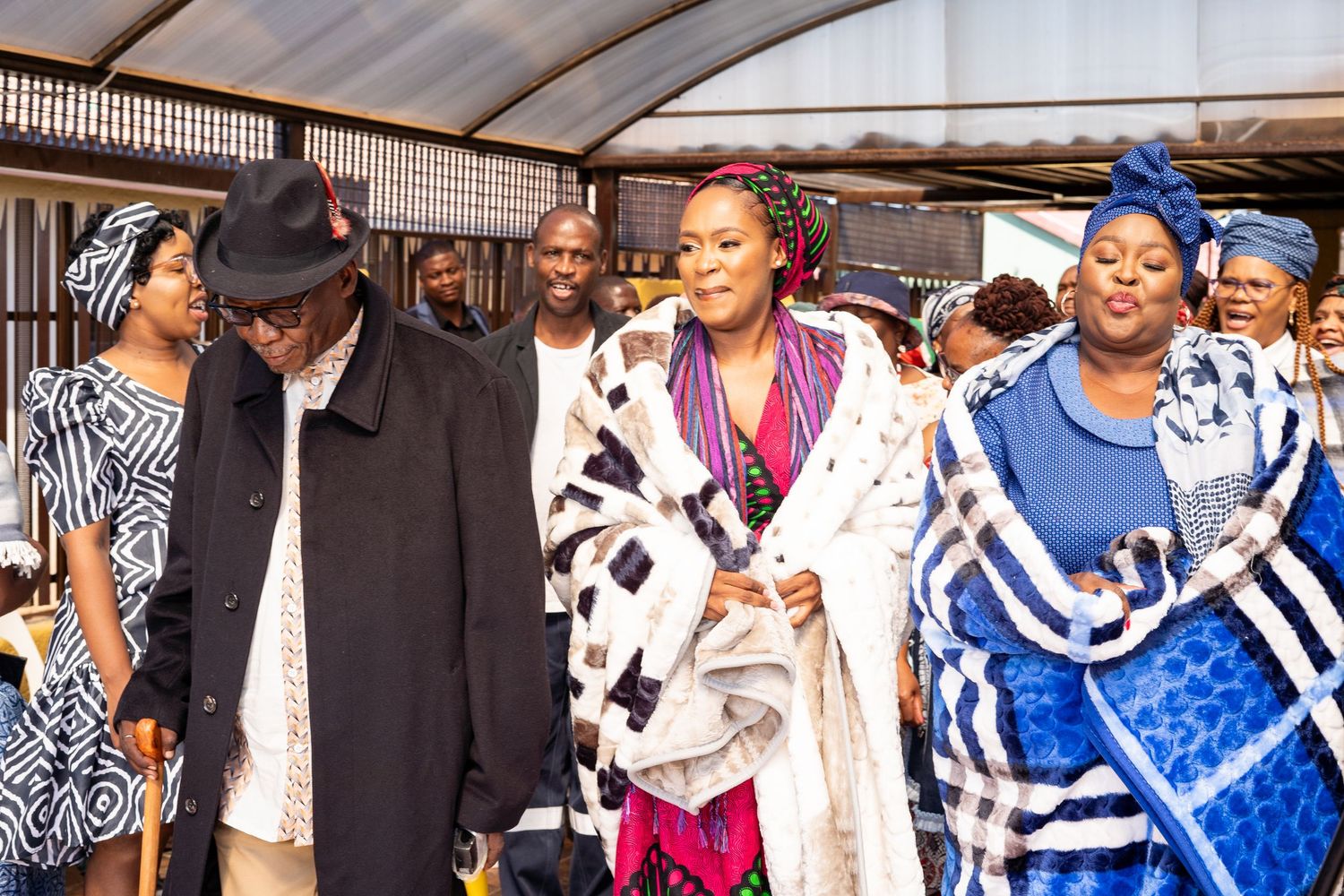 Wedding party walking in traditional African Ndebele blankets during cultural wedding celebration.