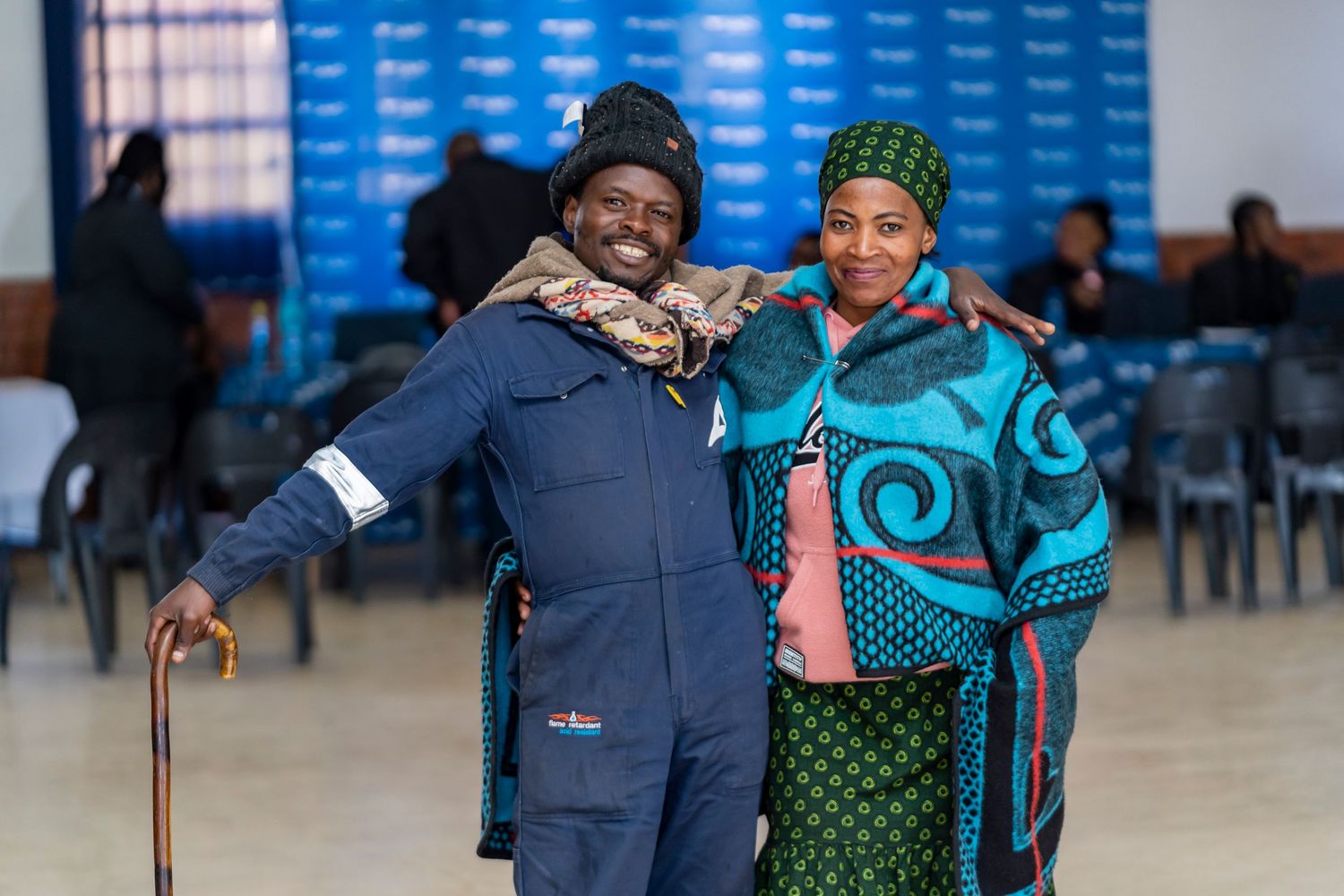 Smiling couple poses together at a community financial literacy event with branded backdrop.
