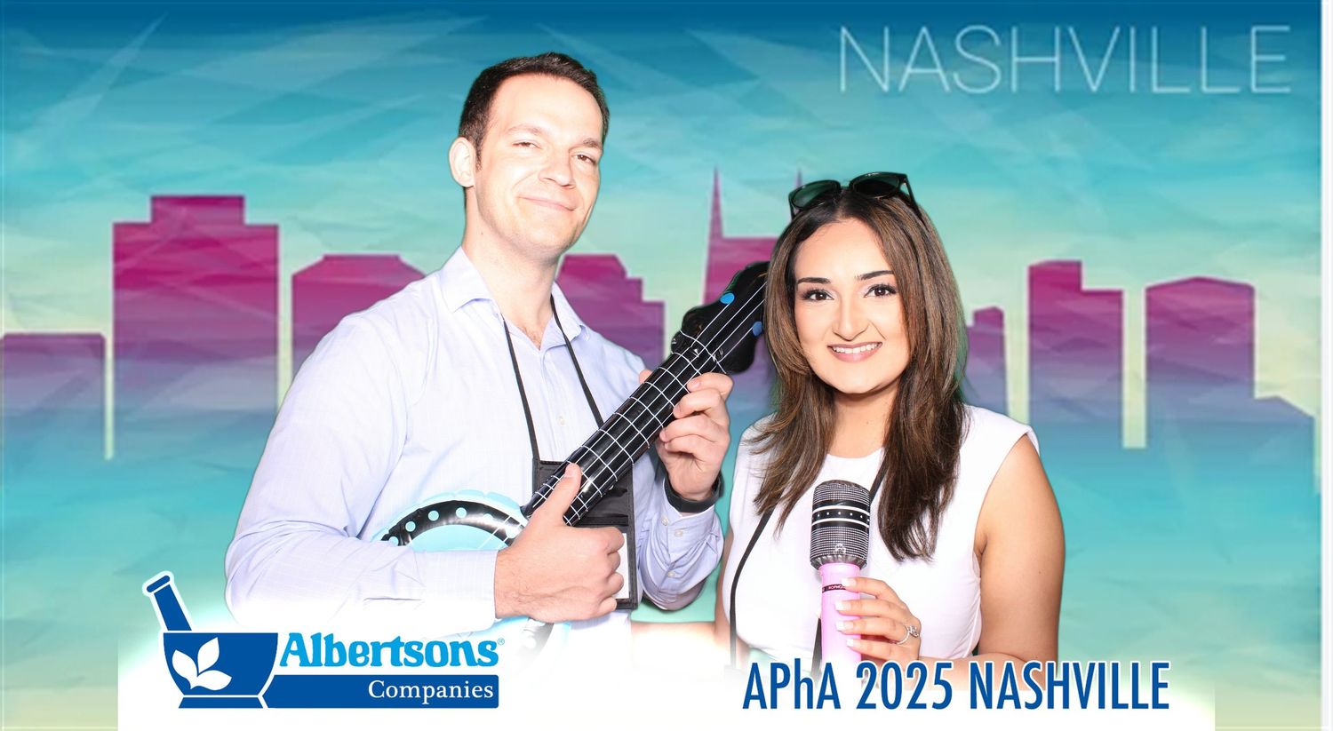 Two people pose with a guitar against a blue Nashville skyline backdrop at APHA 2025 conference event.