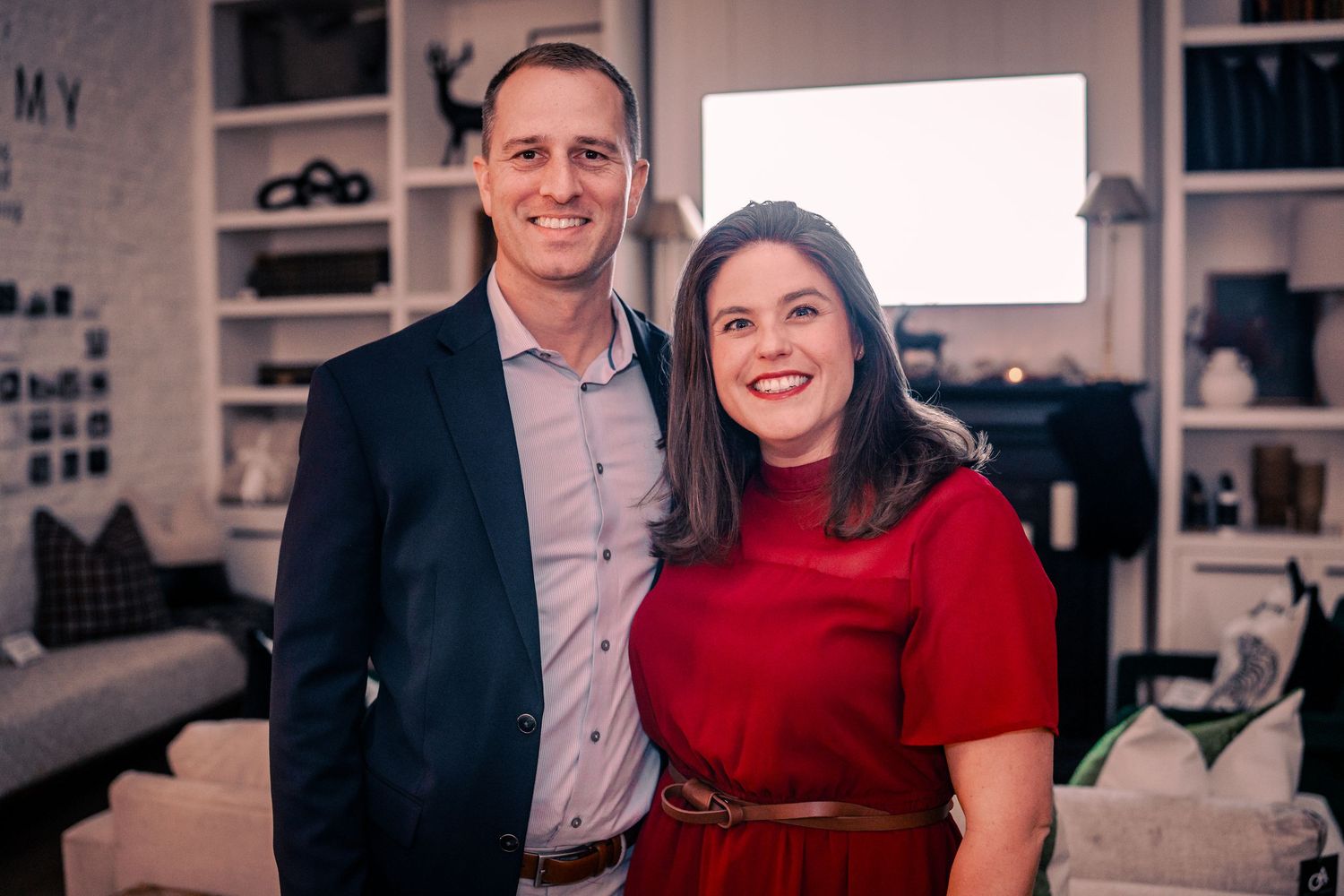 Professional colleagues in business attire smiling together in an office setting.