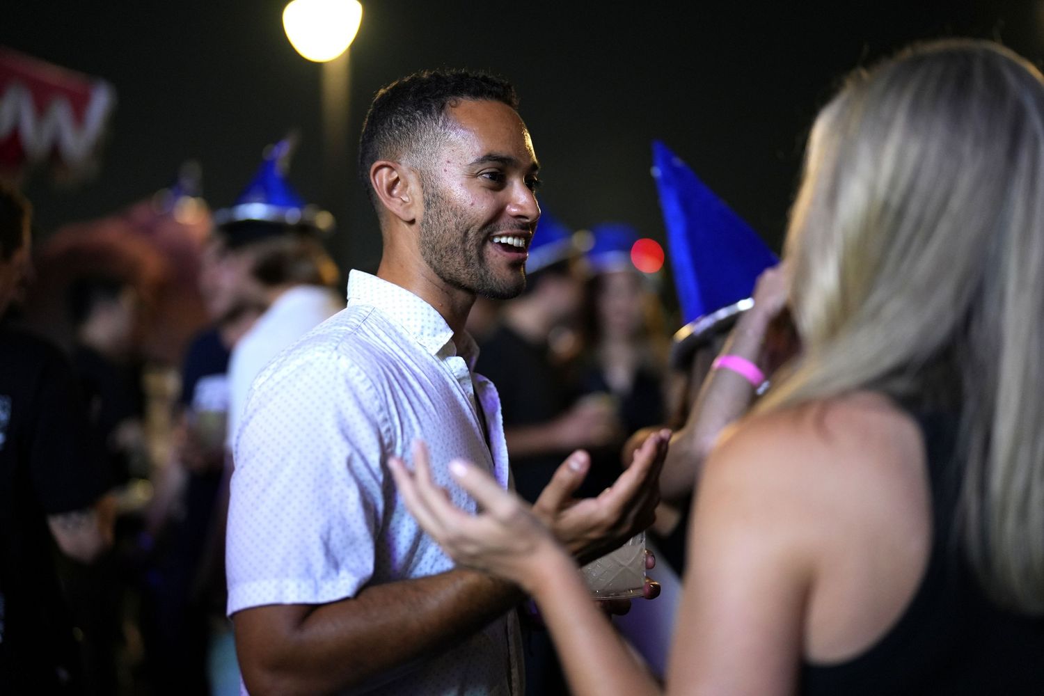 People dancing and socializing at a nightclub with blue lighting.
