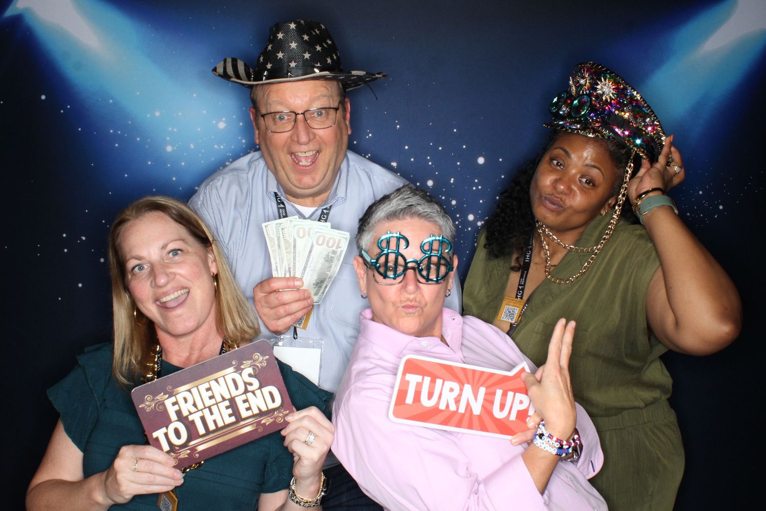 Group photo at a nighttime event with blue lighting and party accessories.