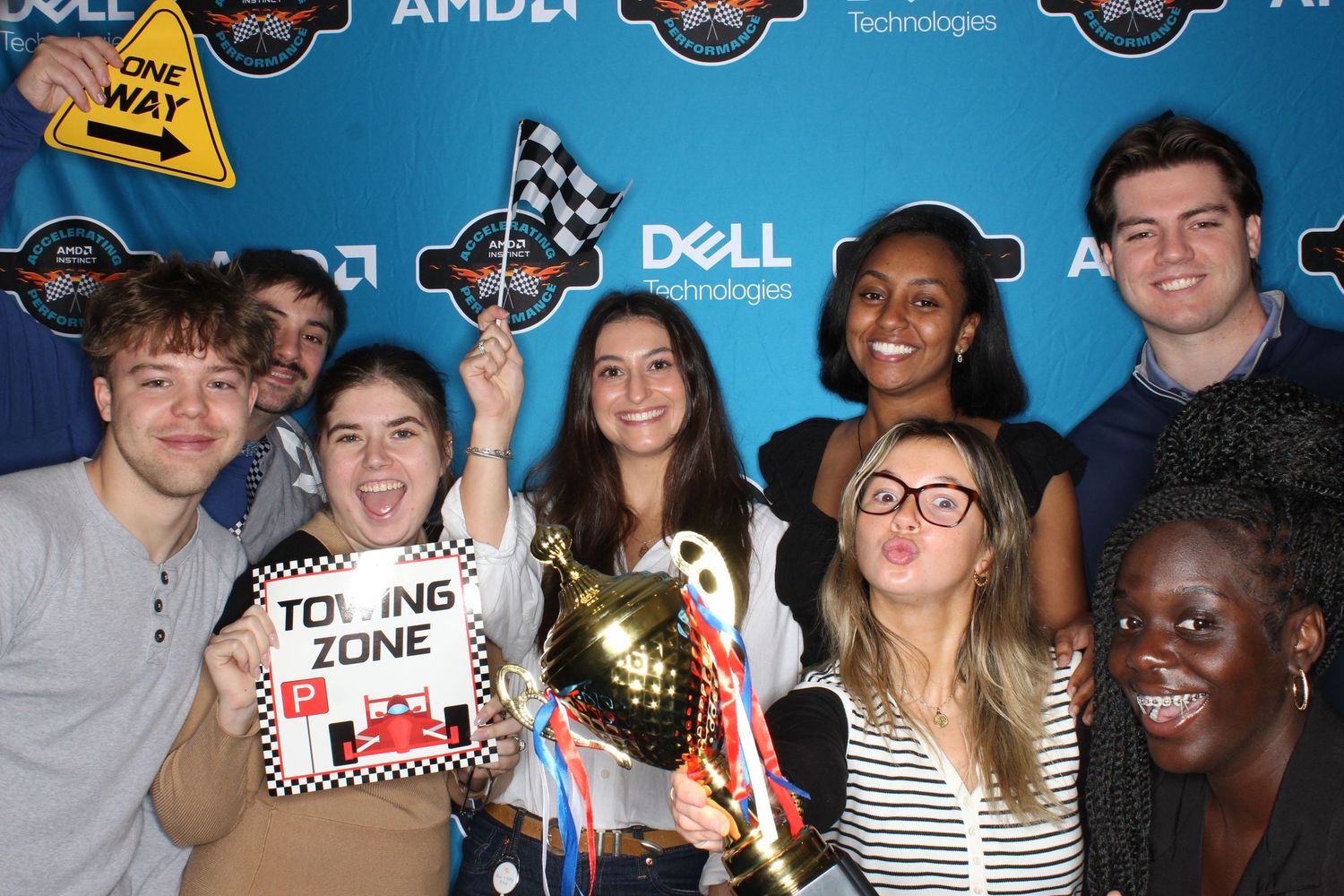 People posing together at a tech event with Dell and AMD logos on a blue backdrop.