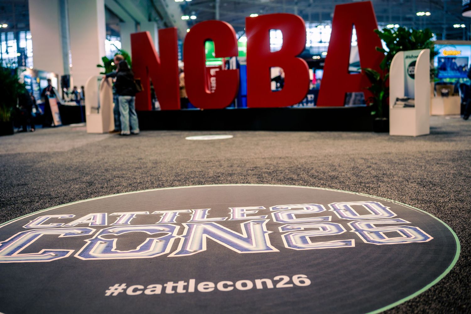 Large red NCBA letters and Cattlecon20 logo displayed at a convention center floor.