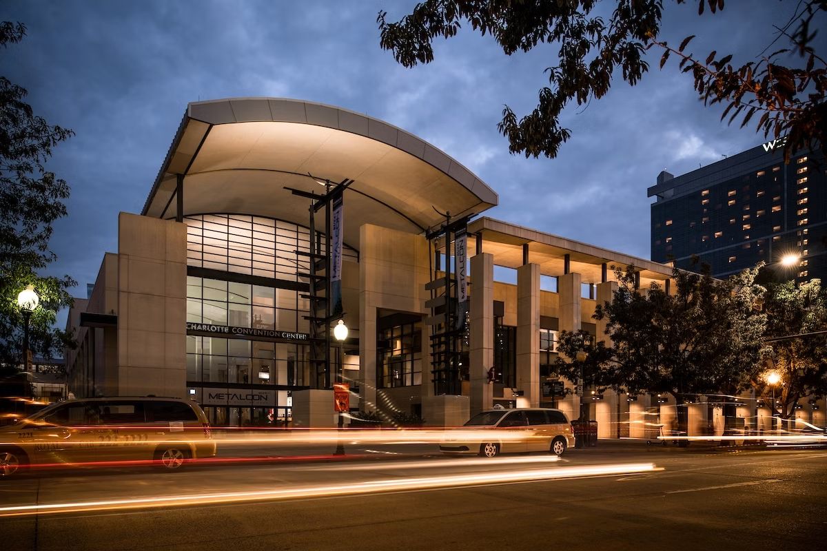 Modern performing arts center building exterior illuminated at dusk with curved architecture and glass facade.
