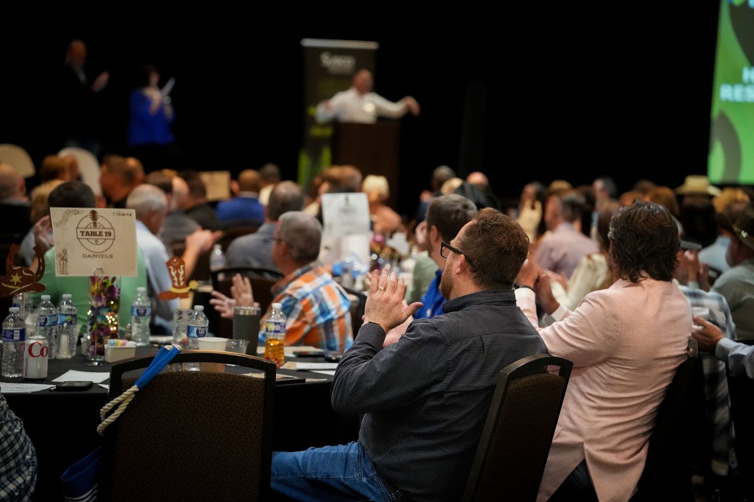 Business conference attendees seated in rows during presentation.