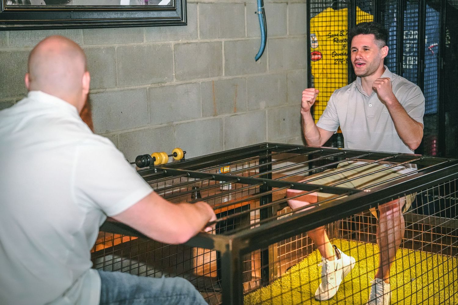People playing games at an indoor entertainment venue with industrial decor.