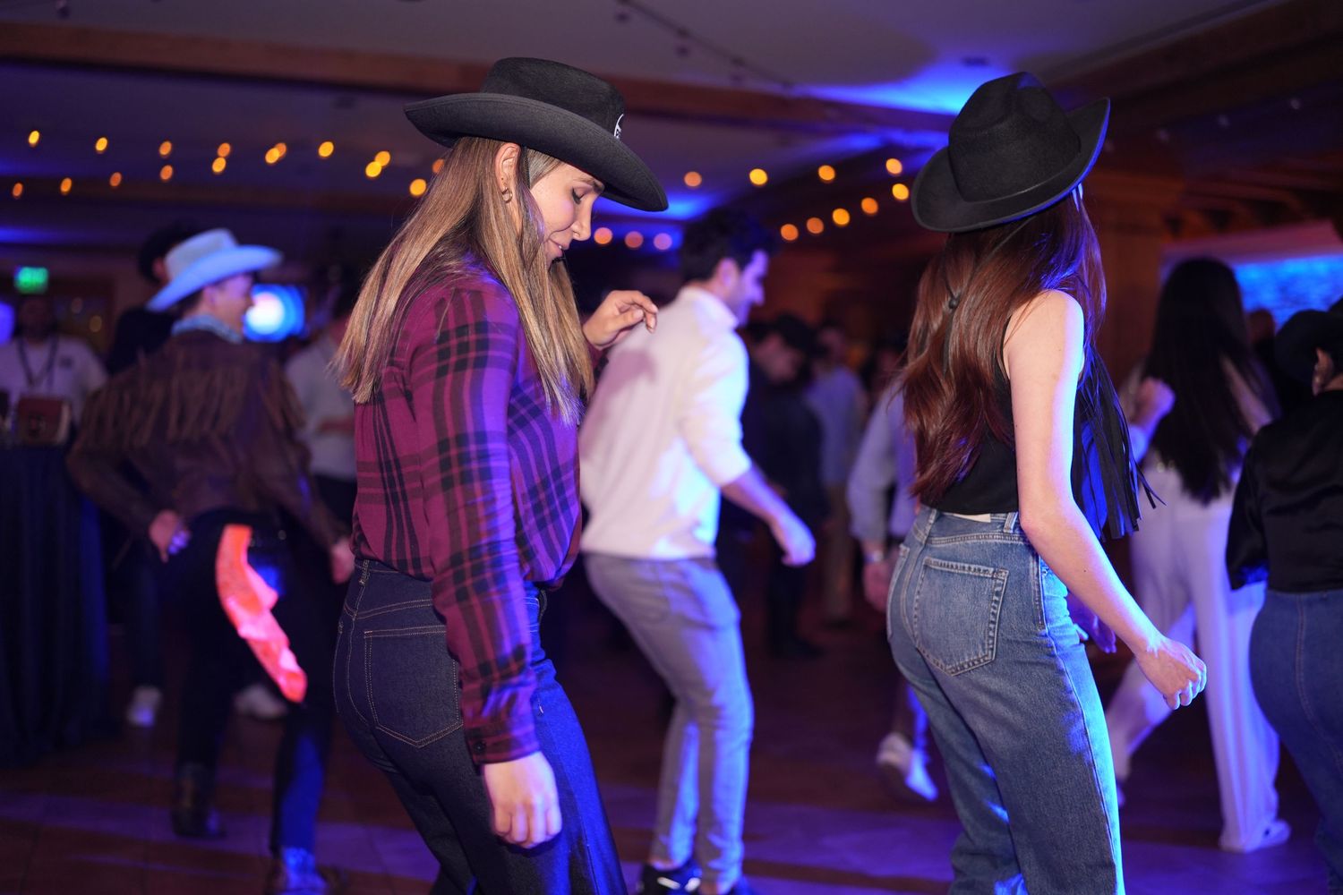 Dance floor with people enjoying a party under blue and purple lighting effects.