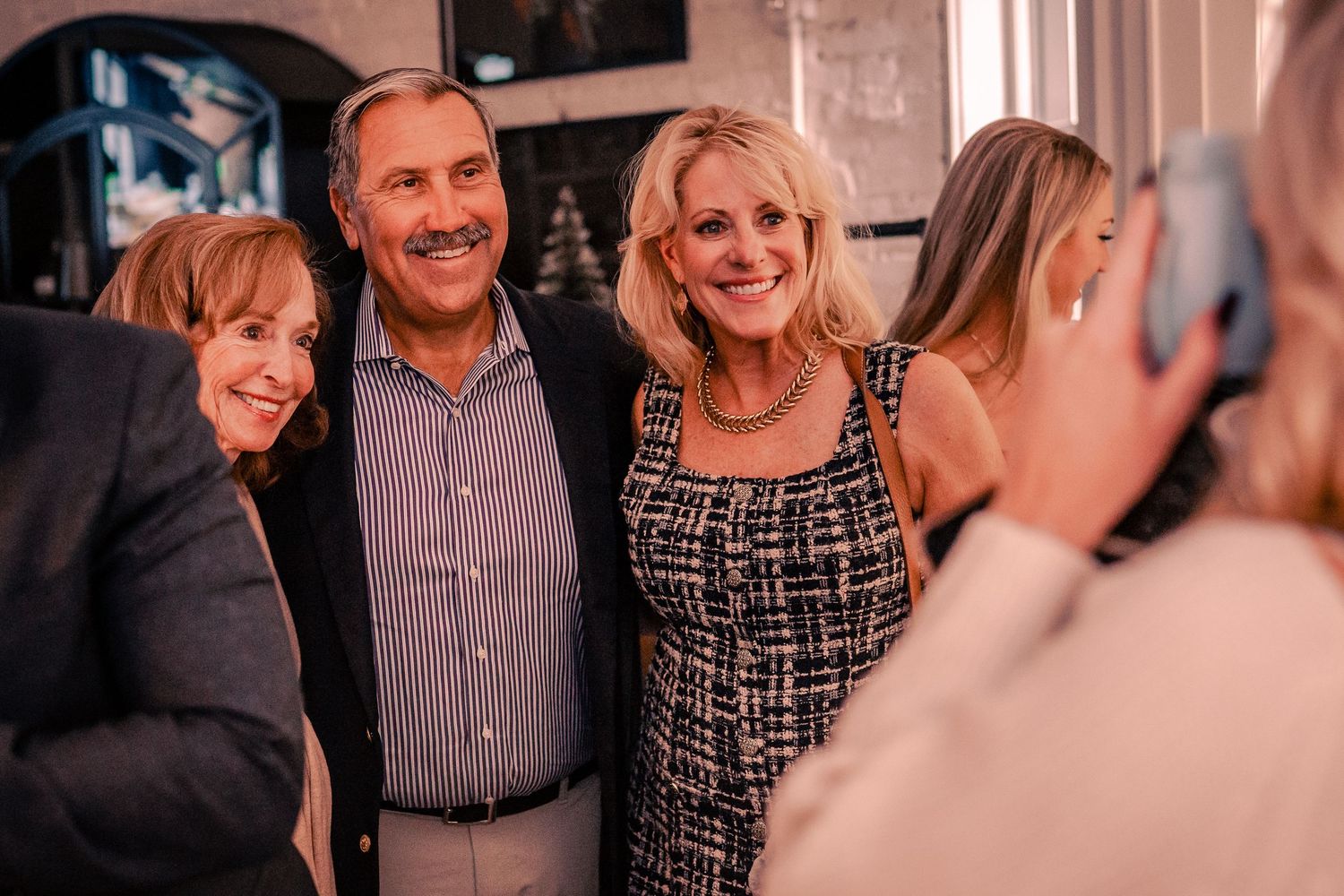 Guests mingling and chatting at an upscale indoor social gathering.