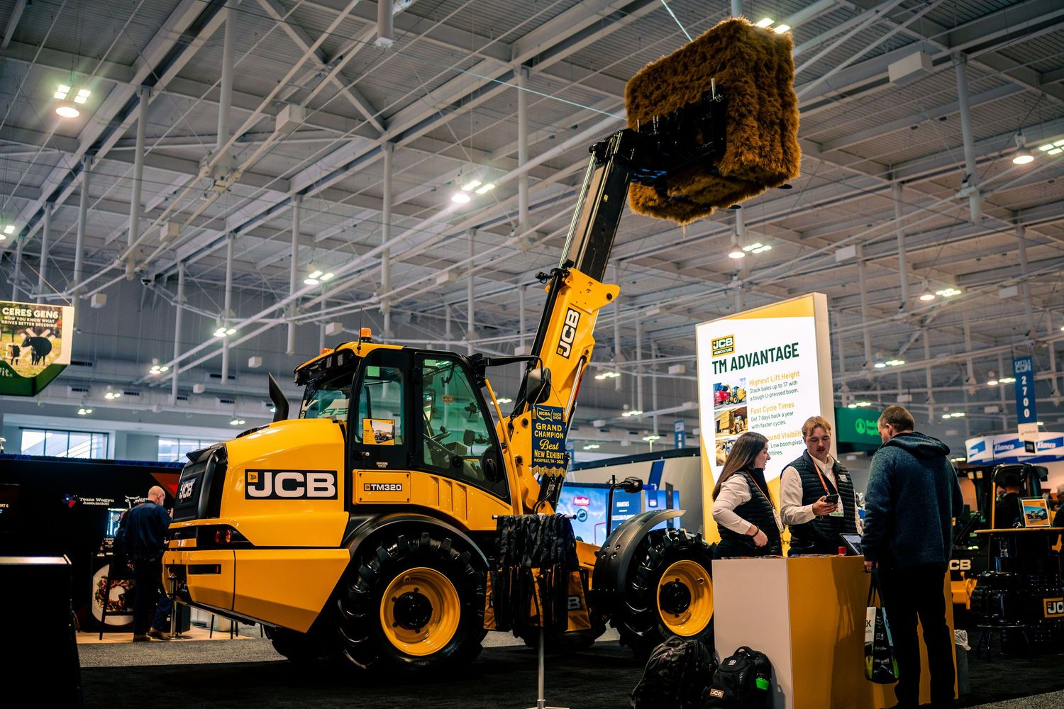 Heavy construction equipment including JCB machinery on display at an indoor industrial equipment exhibition.