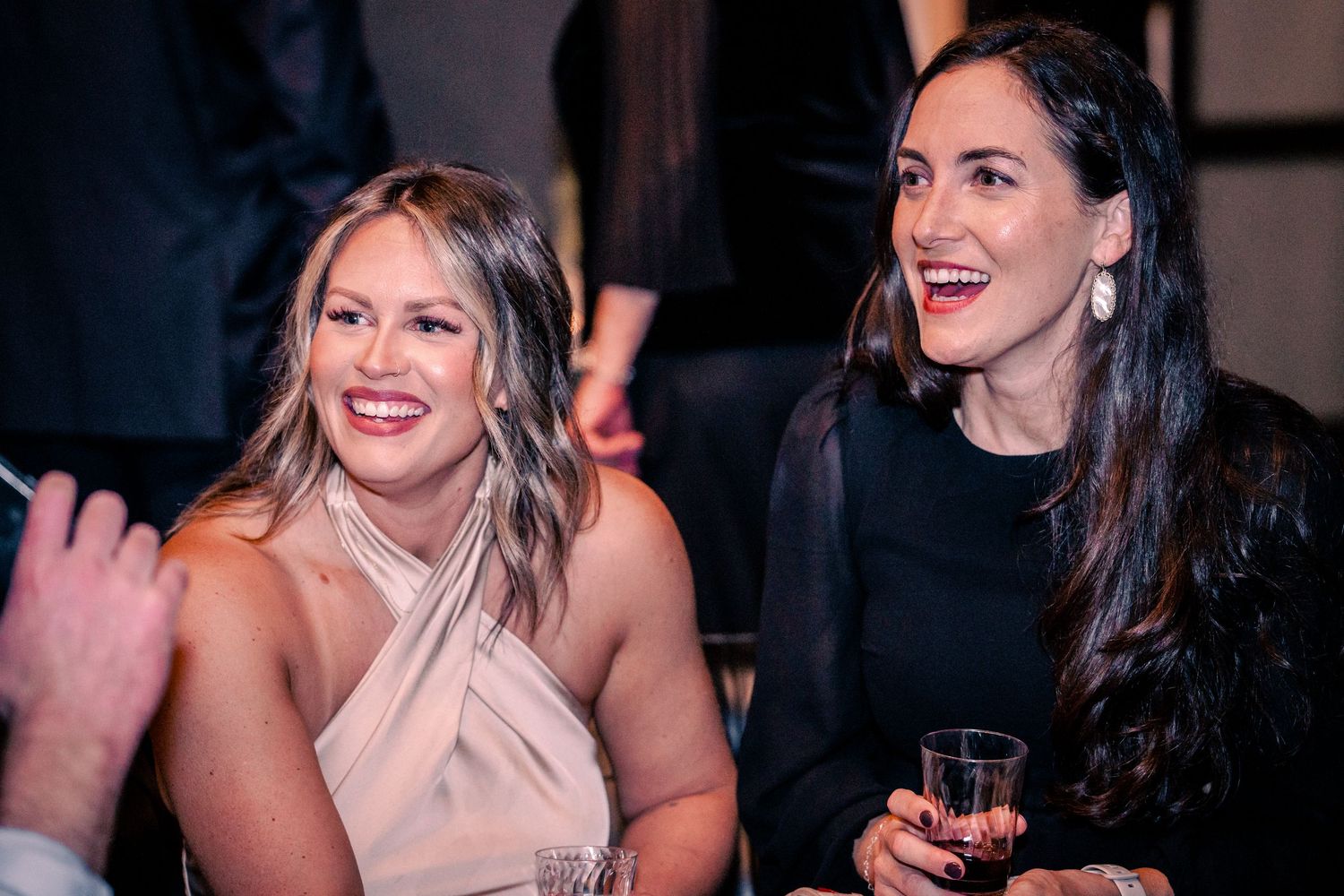 A group of friends share laughs during an evening social event.