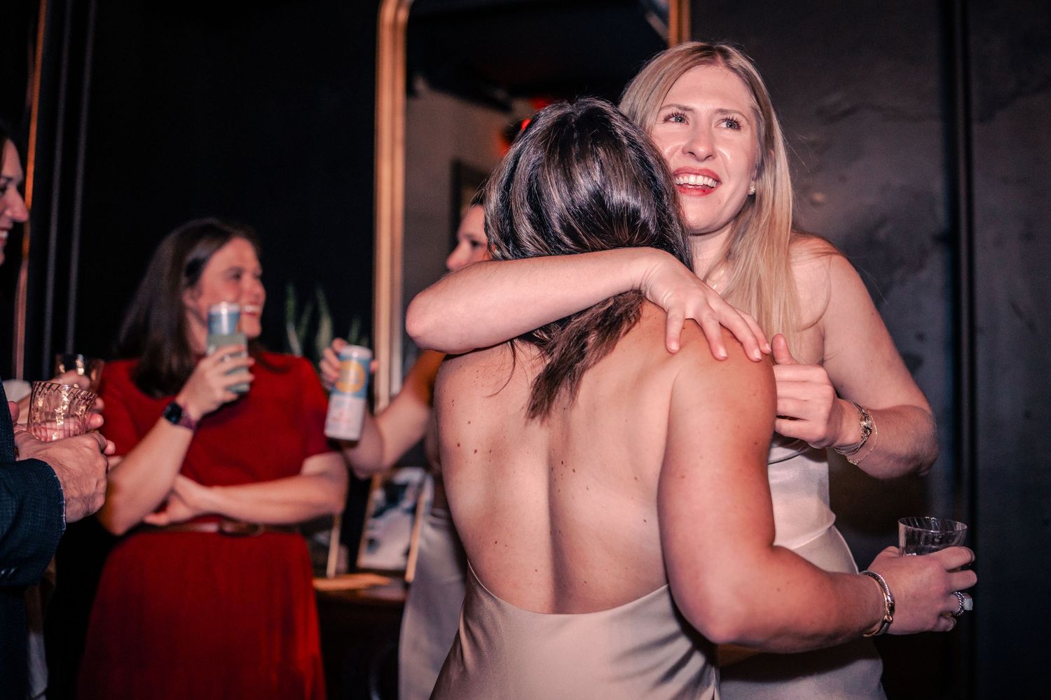 People mingling and enjoying drinks at an evening social gathering.