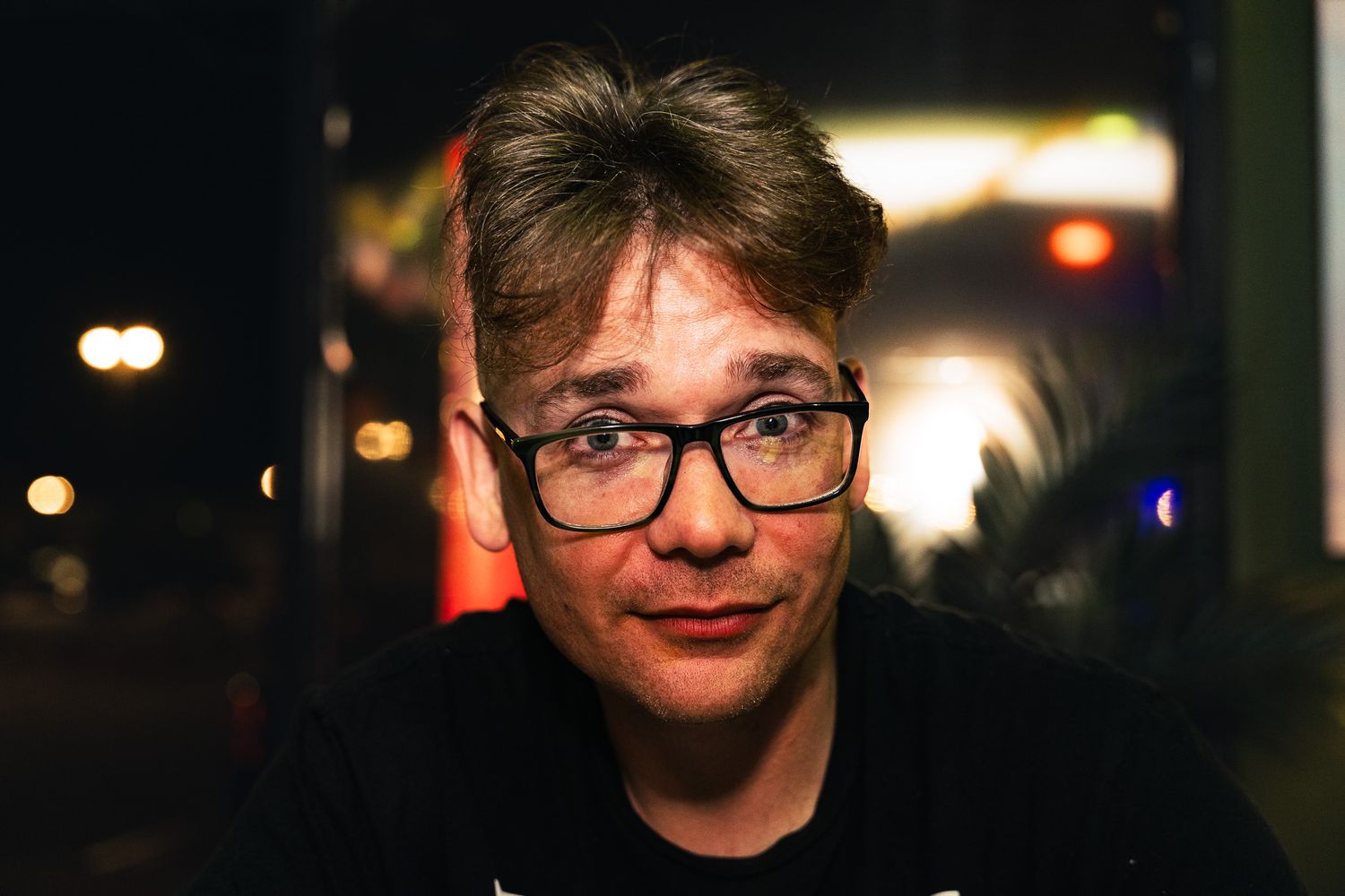 Professional portrait photo of a person standing outdoors with soft natural lighting.