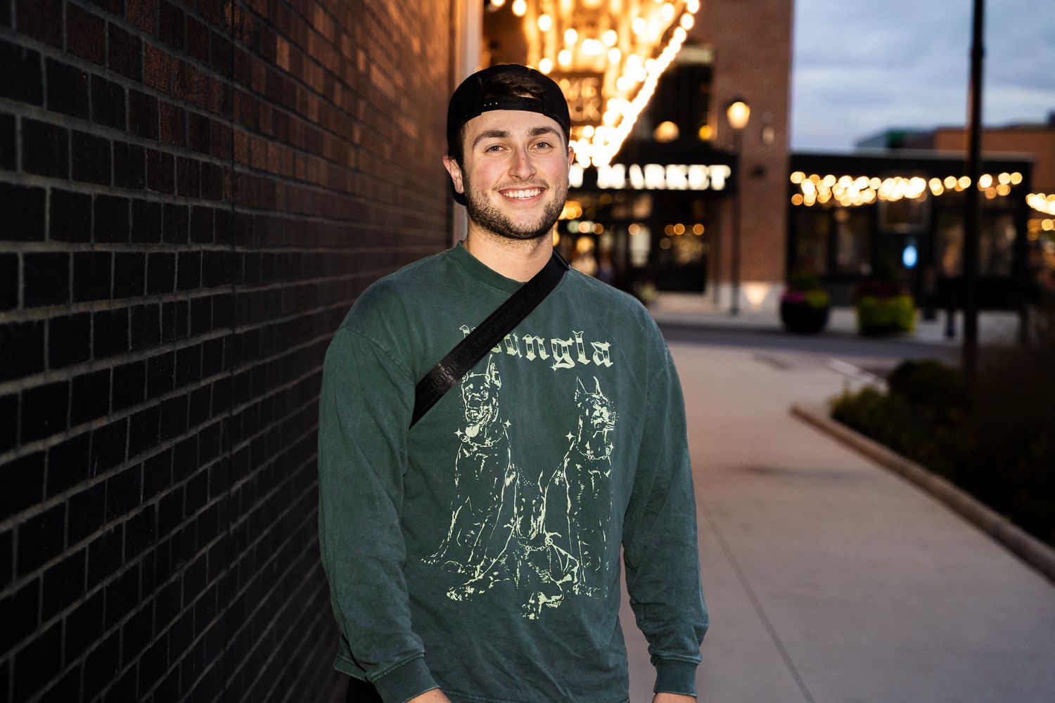 Professional portrait photo of a person standing outdoors with soft natural lighting.