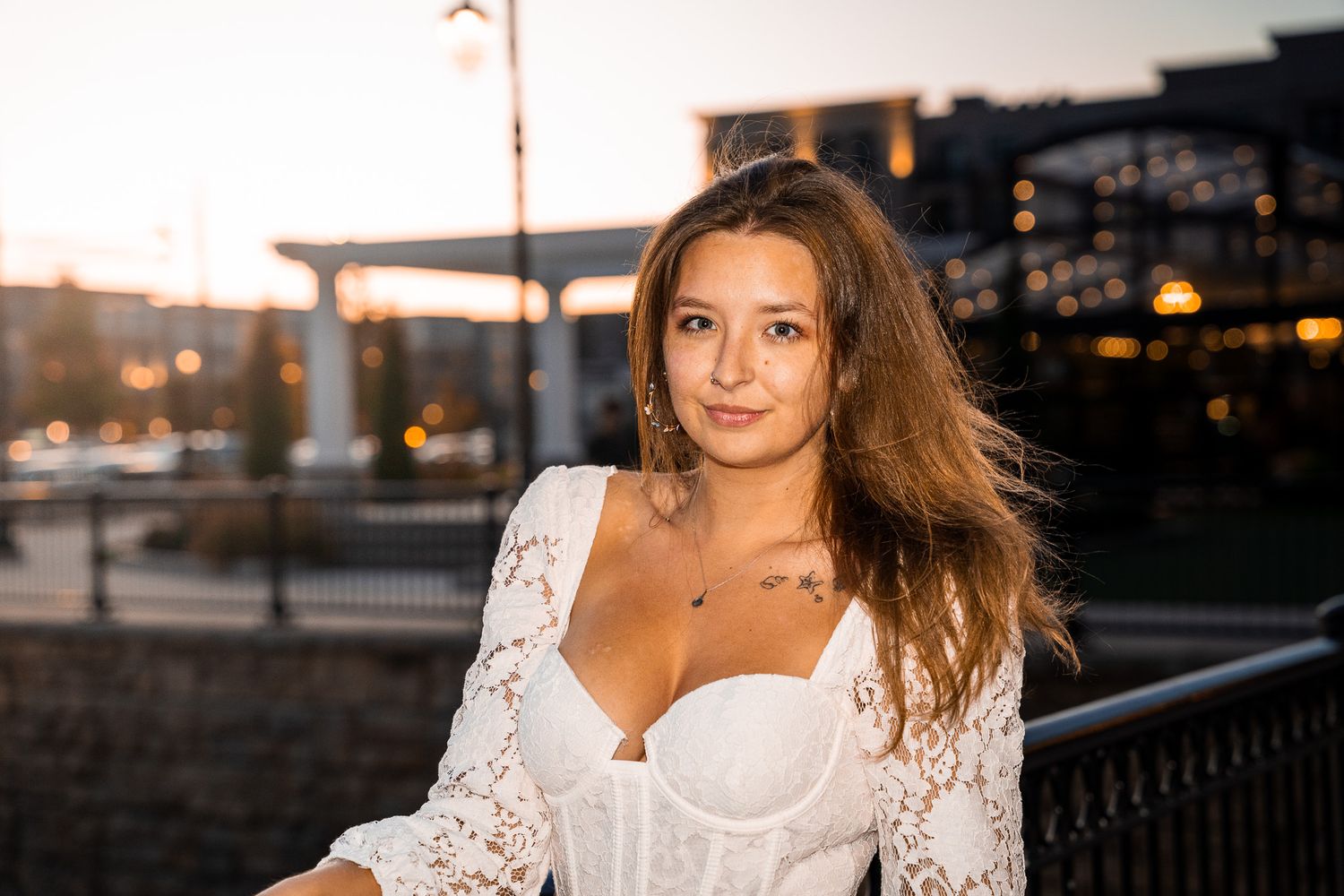 Professional portrait photo of a person standing outdoors with soft natural lighting.