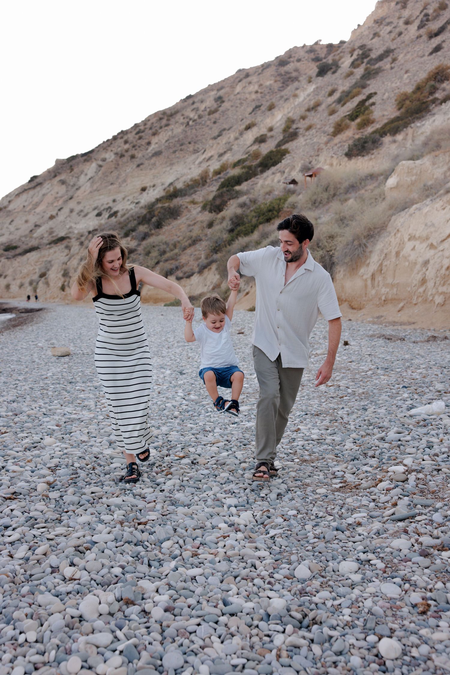 Couple walking along a rocky beach in Cyprus during a sunset photoshoot
