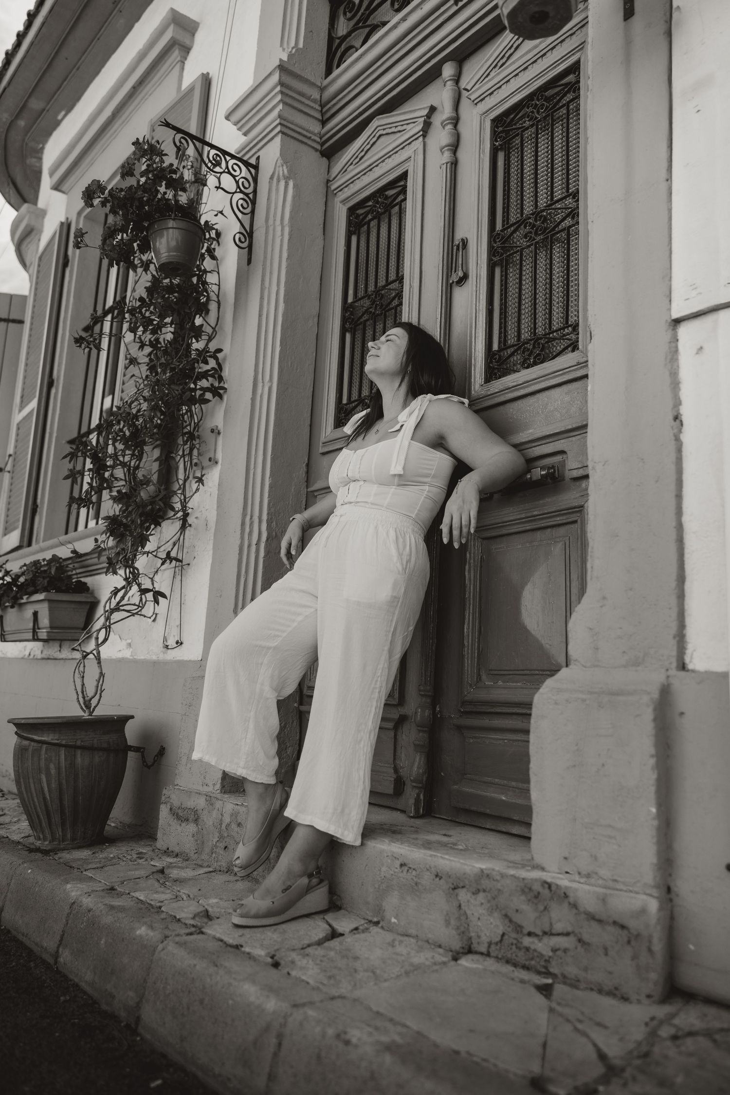 Black and white photo of a couple embracing while standing against historic architecture during a Cyprus photoshoot