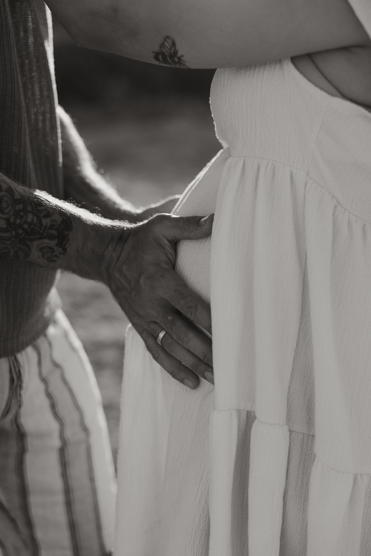 Close-up maternity detail photo of hands on a baby bump during a warm Cyprus photoshoot