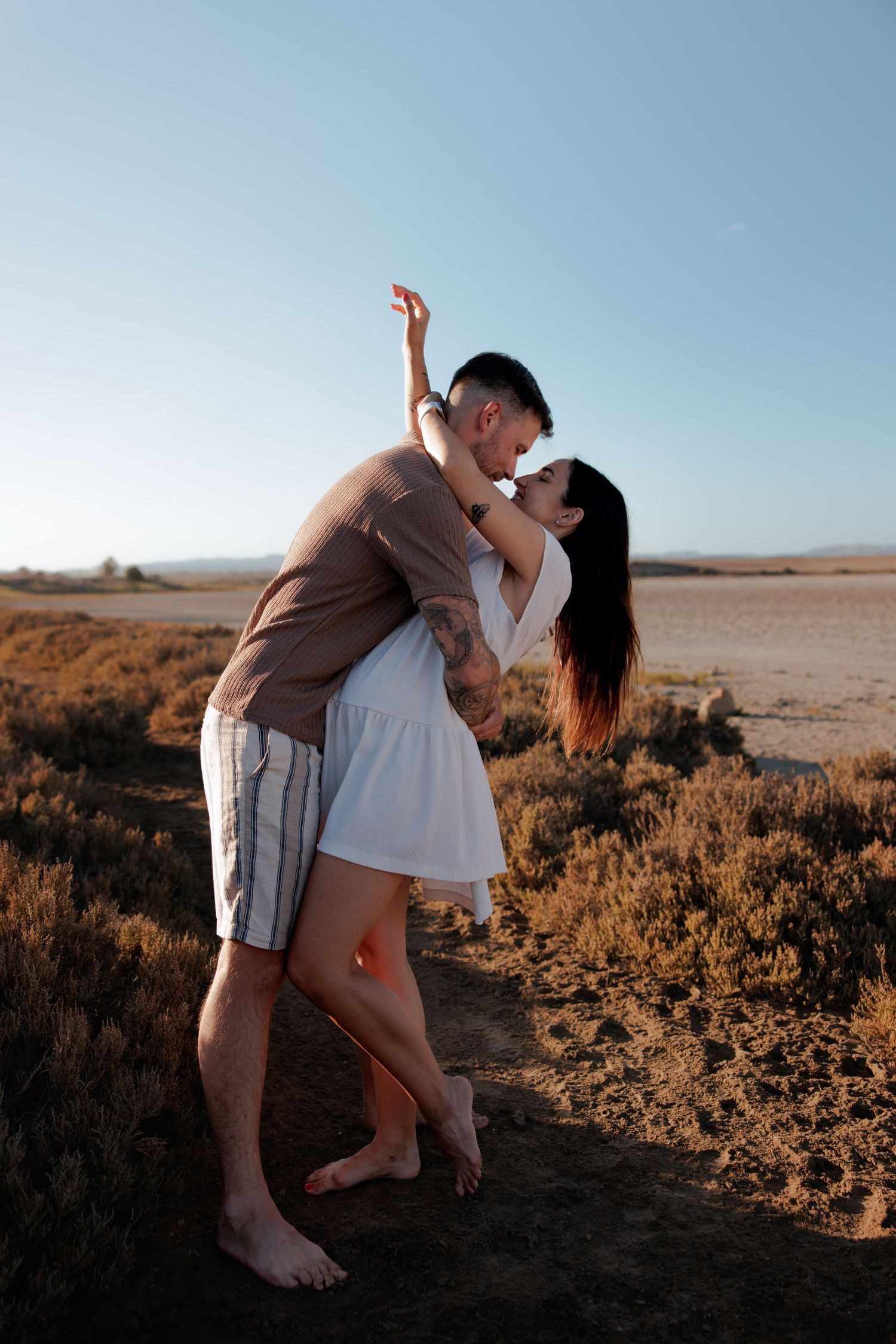 Couple laughing and hugging on a cliffside at sunset in Cyprus