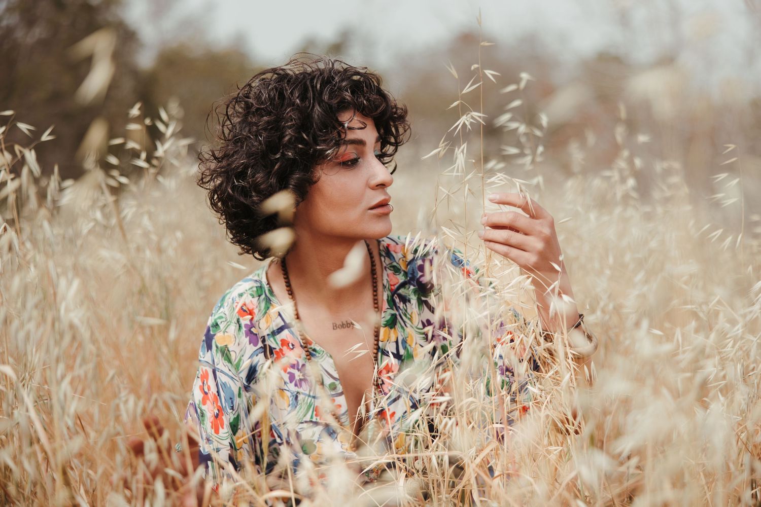 Woman with curly hair standing in a dry field during a lifestyle photoshoot in Cyprus Larnaca Salt Lake