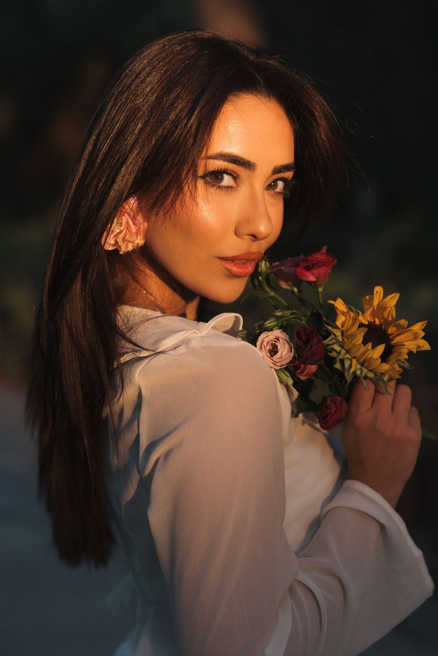Woman holding a bouquet during a warm golden hour portrait session in Cyprus
